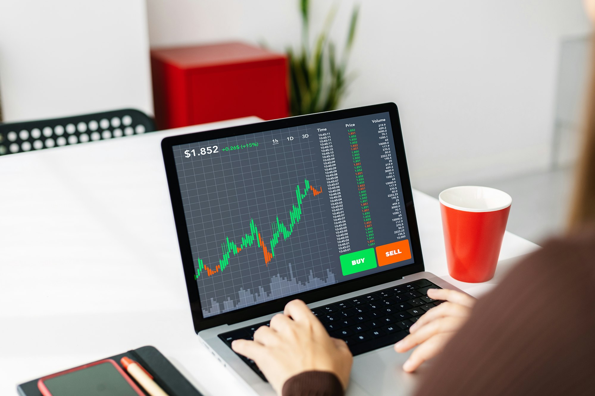 Young woman investor working on laptop at home