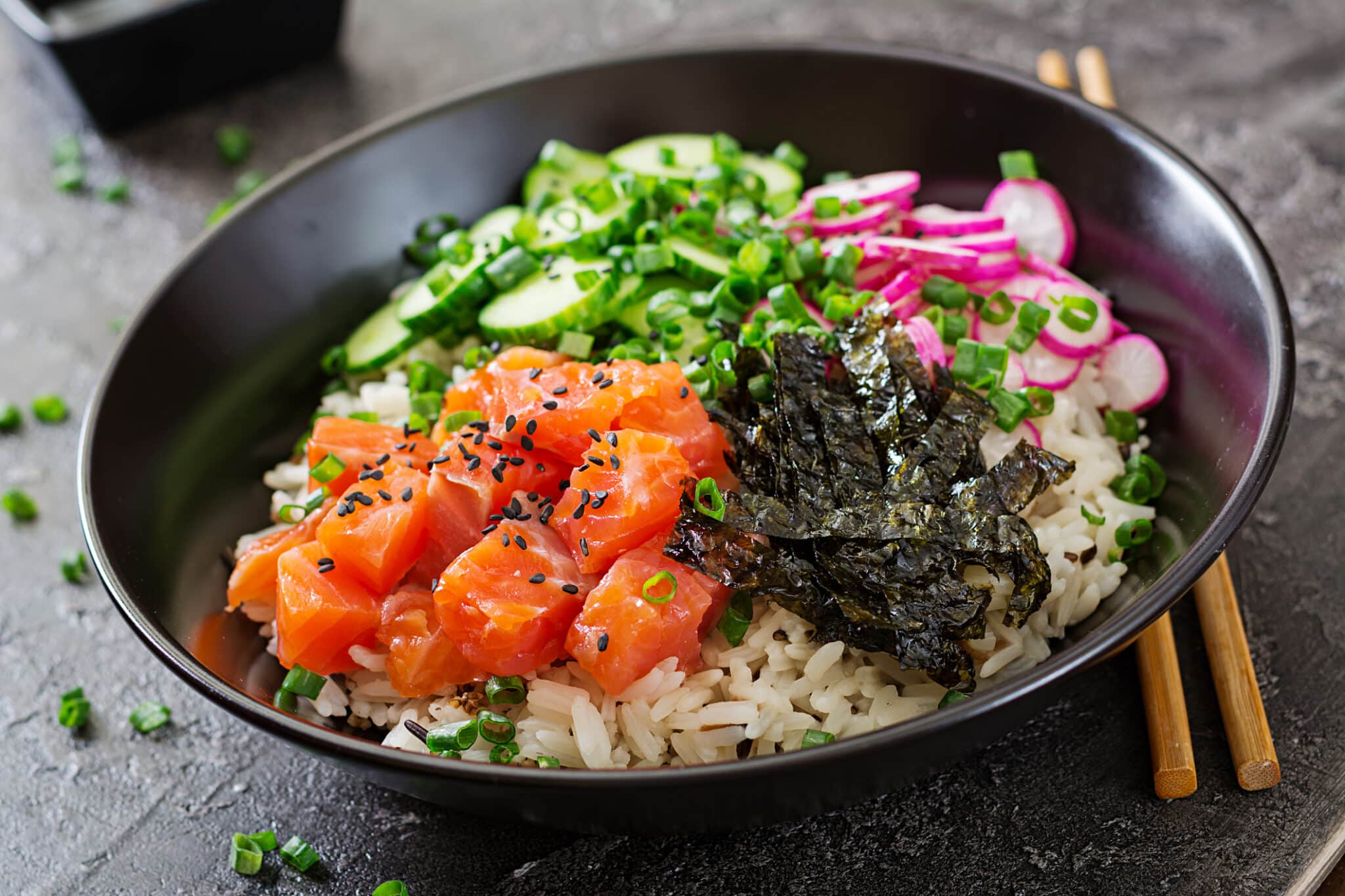 poke bowl di pesce salmone hawaiano con riso, ravanello, cetriolo, pomodoro, semi di sesamo e alghe. ciotola del budda. cibo dietetico