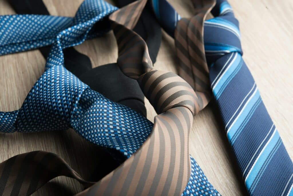 Silk neck ties on wooden background.