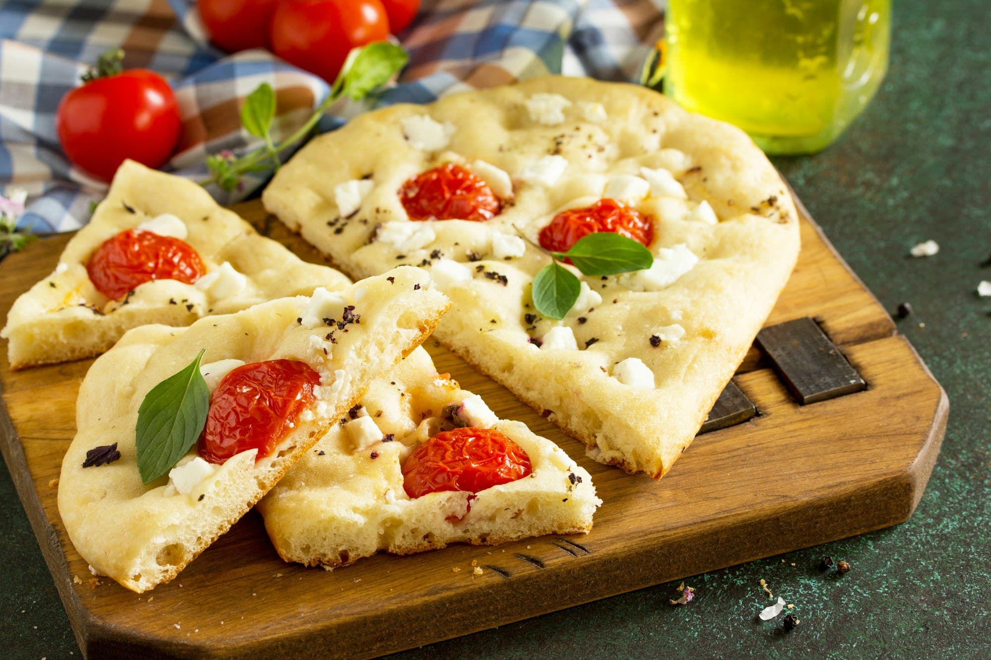 Traditional Italian Focaccia with rosemary, tomatoes and feta - homemade flat bread focaccia.